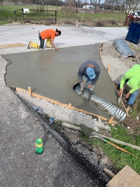 concrete workers leveling culvert drain pipe